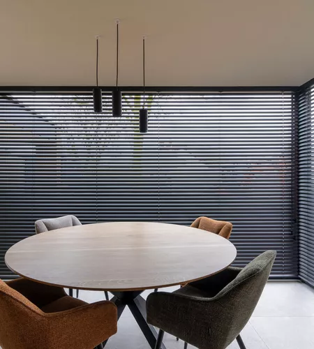 Zwarte aluminium lamellen in woonkamer in Marke geplaatst door Altex Raamdecoratie