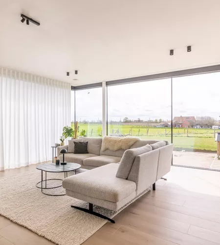 Witte schuifgordijnen in woonkamer in Moorslede