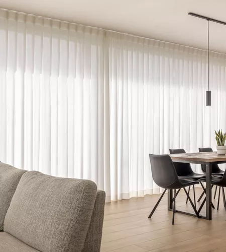 Witte schuifgordijnen in woonkamer in Moorslede