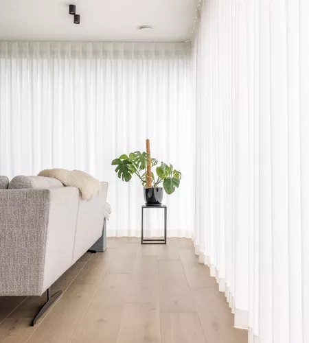 Witte schuifgordijnen in woonkamer in Moorslede