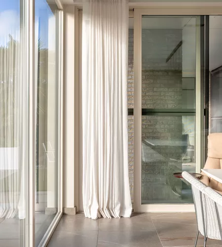 Witte schuifgordijnen geplaatst in moderne keuken door Altex Raamdecoratie