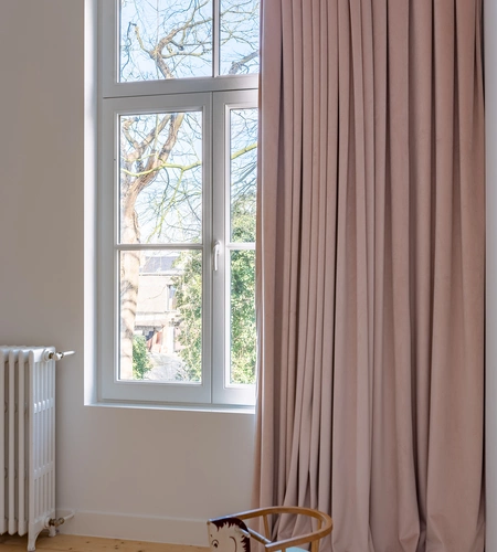 Roze velours schuifgordijnen in statige villa.