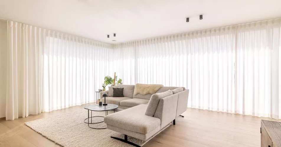Witte schuifgordijnen in woonkamer in Moorslede