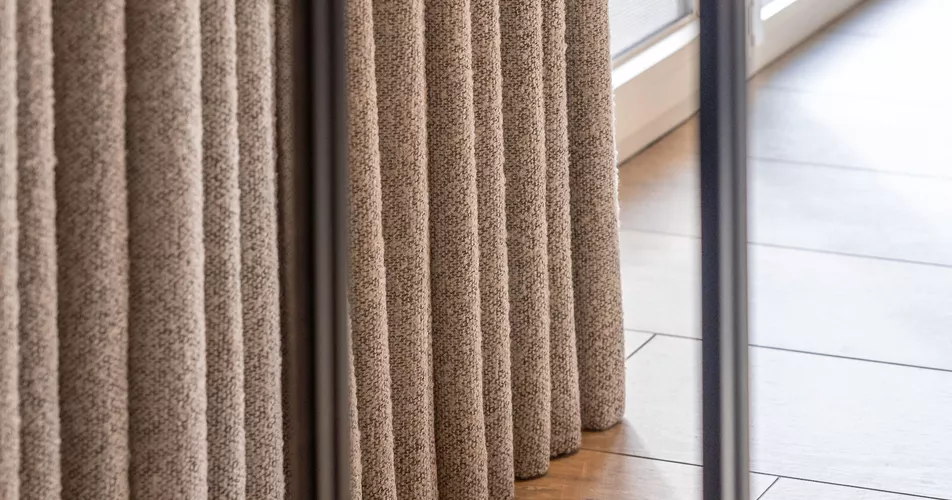 Mooie volle schuifgordijnen met wolstructuur in slaapkamer geplaatst door Altex Raamdecoratie