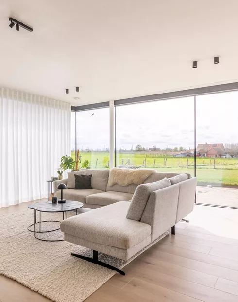 Witte schuifgordijnen in woonkamer in Moorslede