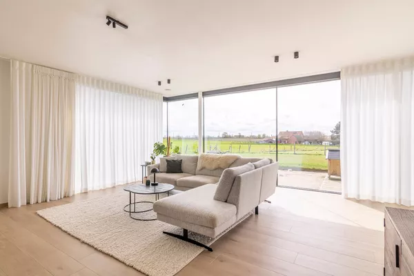 Witte schuifgordijnen in woonkamer in Moorslede